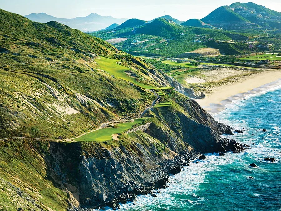 Golfer teeing off with ocean view at a Cabo San Lucas golf course