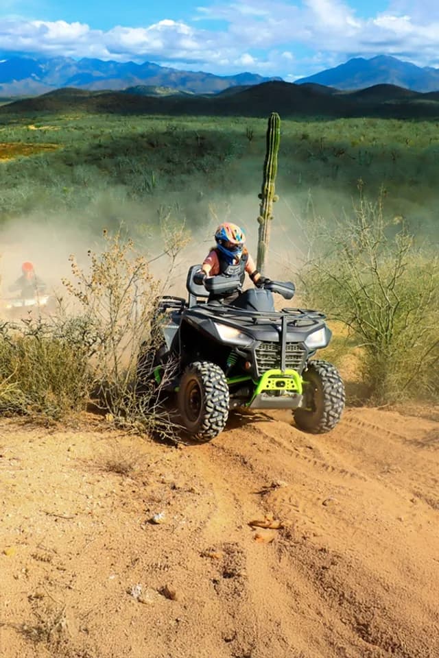 Atv rider at Tania's 2026 Local Guide to Unforgettable Cabo Trek Whale Watching on dusty trail, desert landscape