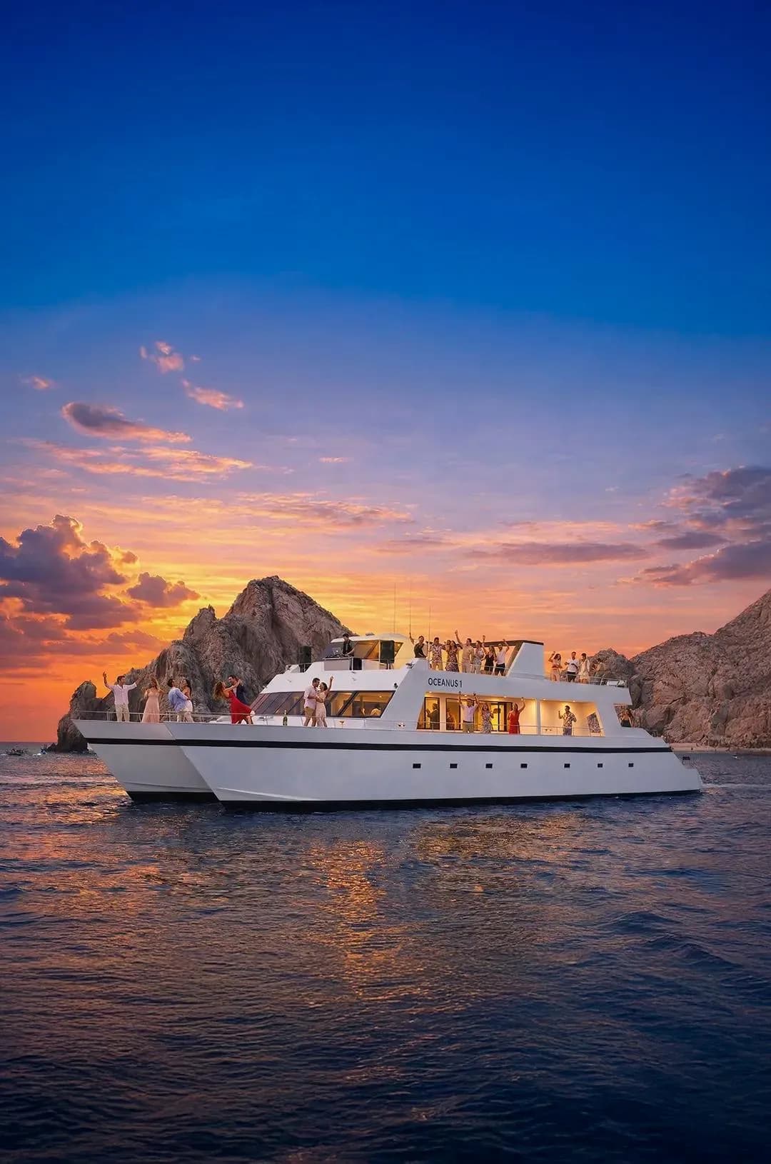 Catamaran party at Helicopter Tour Cabo Cost at sunset, with mountains beyond