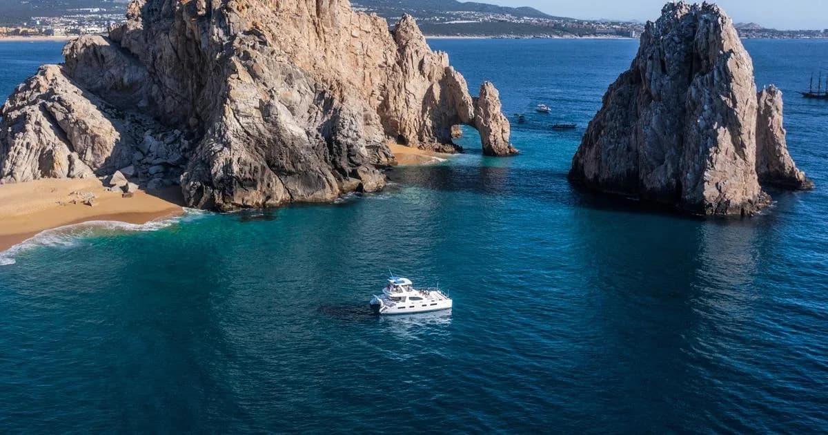 Rock arch at Embracing Baja: Your 2026 Cabo San Lucas Local Customs & Culture Guide with boat in blue ocean