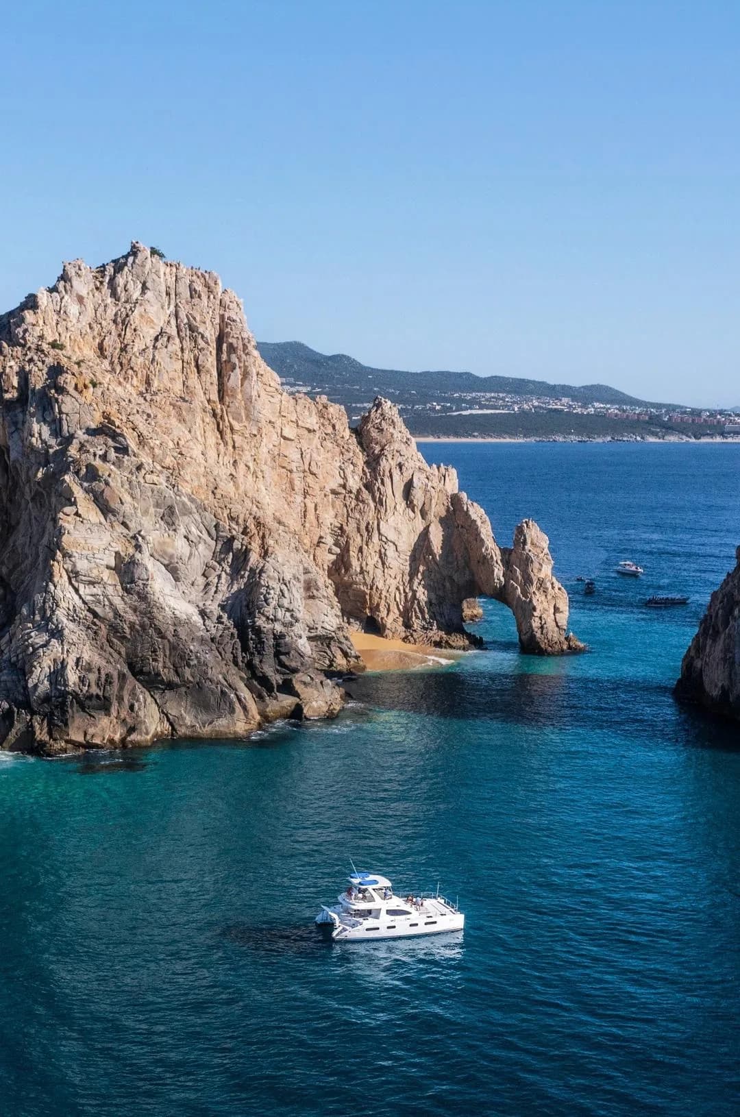 Rock arch 2 at How Much Does Snorkeling Cost in Cabo 2026? Your Ultimate Guide with boat in turquoise water