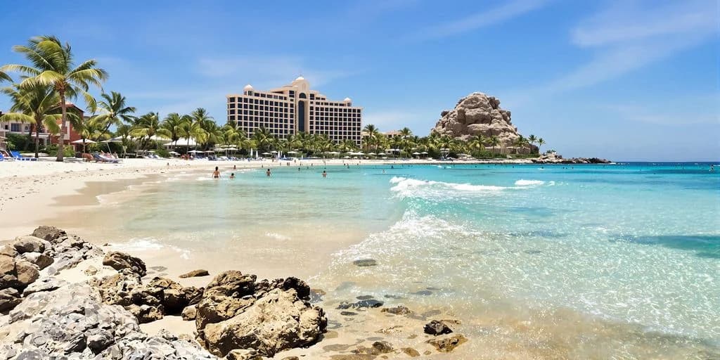 Beach resort at Cabo All Inclusive Unfiltered: What You Need to Know with large hotel, people swimming