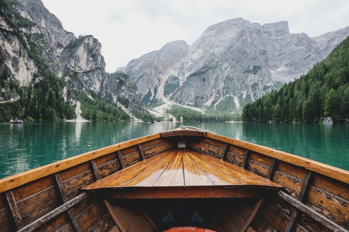 Wooden boat at Cabo Vacation Packages Including Flights from Major US Cities on lake, with mountains beyond