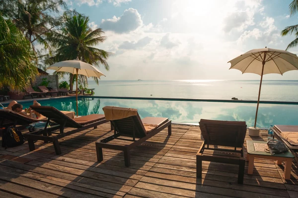 Infinity pool at Cabo Vacation Packages With Villa Stays vs Resort Comparisons with lounge chair, ocean beyond