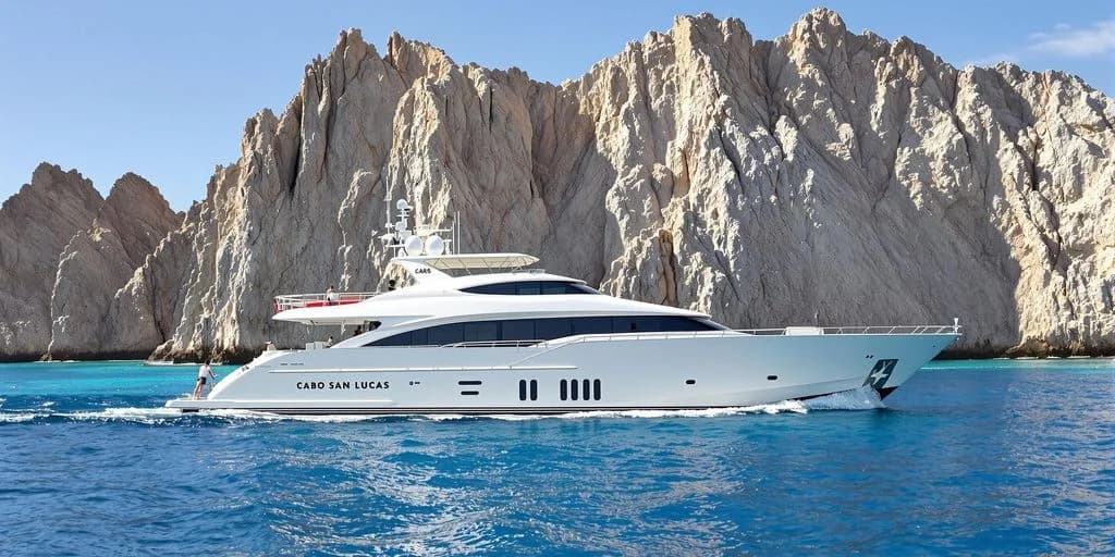 Luxury yacht 1 at Cabo Yacht 2026: What You Need to Know cruising past rocky cliffs, sunny
