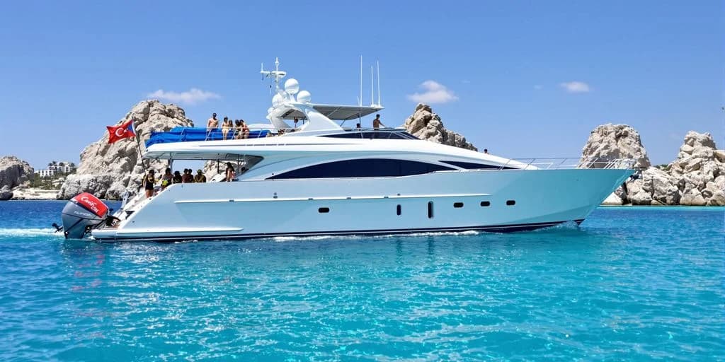 Luxury yacht 2 at Cabo Yacht Charters That Include Snorkel Gear, Food & Open Bar cruising on blue water, with rock