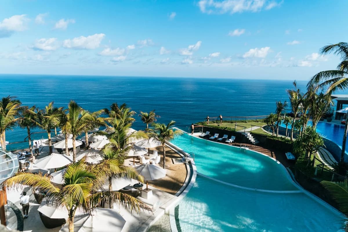 Infinity pool at Luxury Cabo Vacation Packages Under $5,000 for Two People overlooking ocean, with palm trees