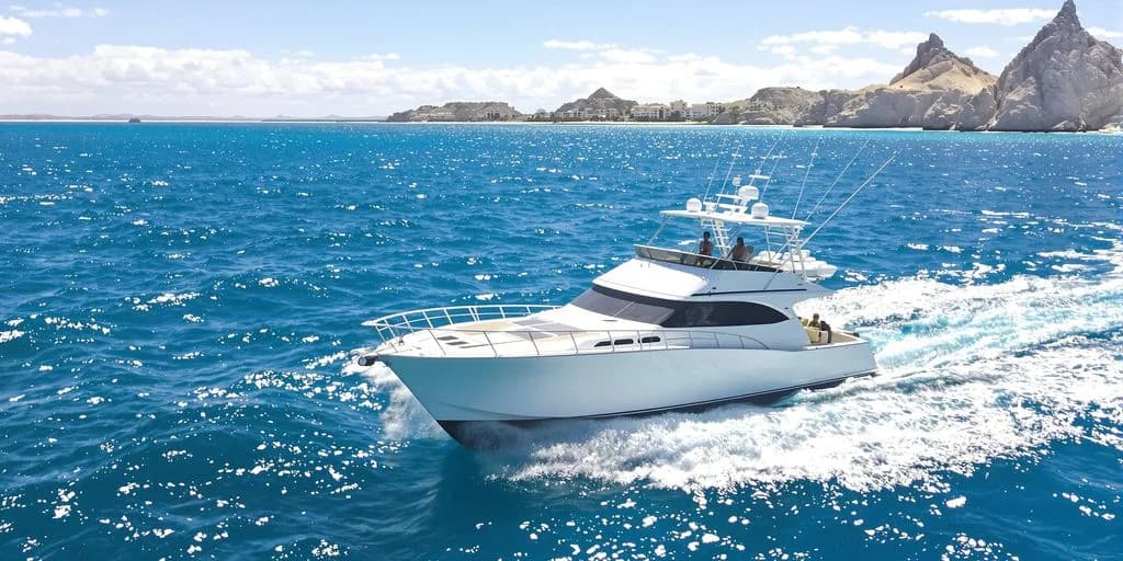 Luxury yacht at Private Cabo Fishing Boats for $3,200 (Up to 8 People) cruising on blue ocean, mountains beyond