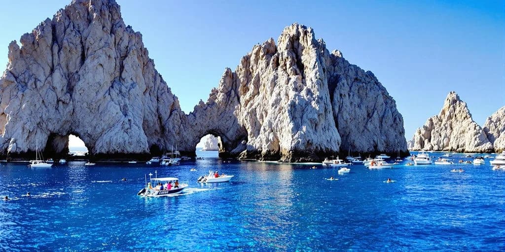 Rock arch at Ultimate Guide to Fishing in Cabo San Lucas boats in water, clear sky