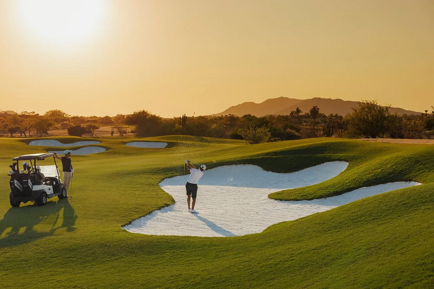 Golfers on a green at sunset in Los Cabos