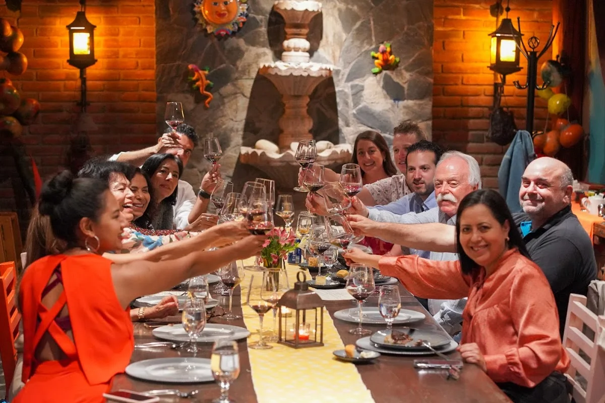 Friends raising wine glasses in a toast around a dinner table