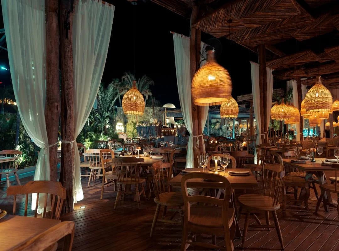 Outdoor restaurant at Chambao Los Cabos at night, with hanging lights in San José del Cabo
