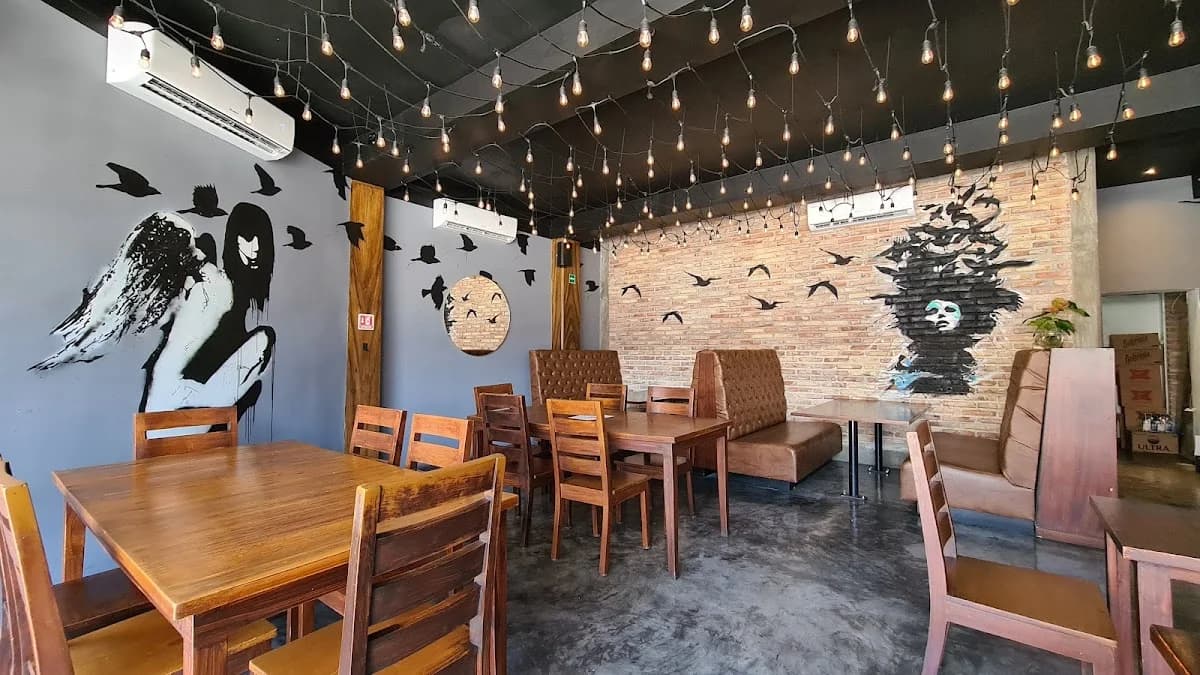 Indoor restaurant at Chubby Noodle Cabo with string lights, brick wall in Cabo San Lucas