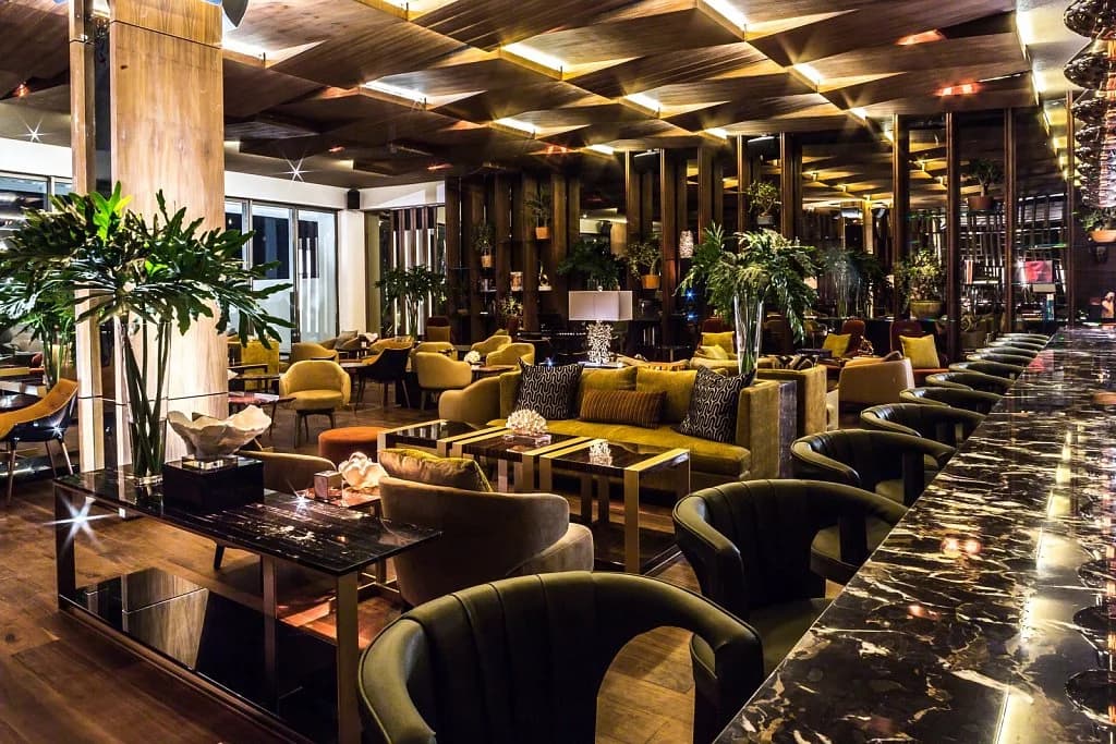 Lounge area at Cocina de Autor with patterned ceiling, warm lighting in Cabo San Lucas