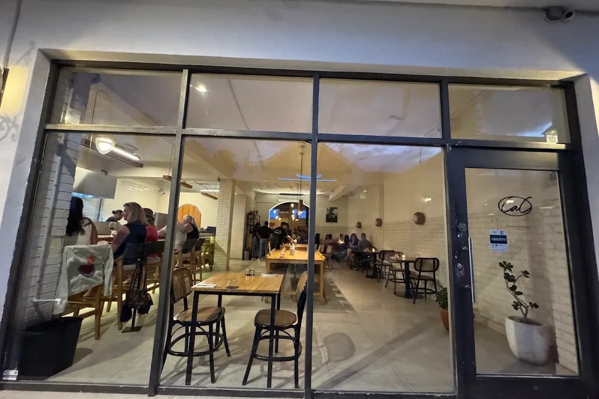 Indoor restaurant at Come a Casa seen through glass window in San José del Cabo