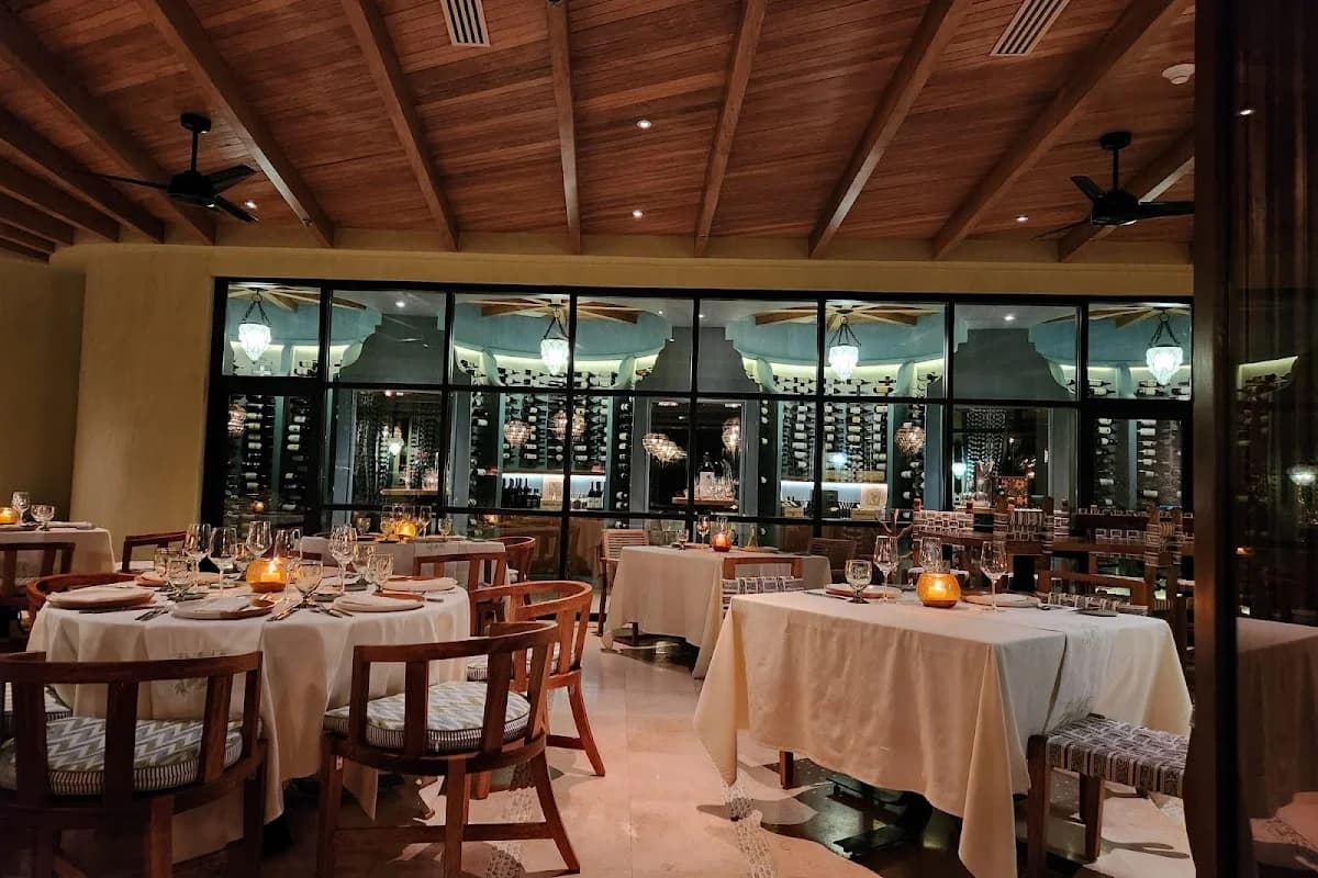 Indoor restaurant at Don Manuel's with wine cellar behind glass in Cabo San Lucas