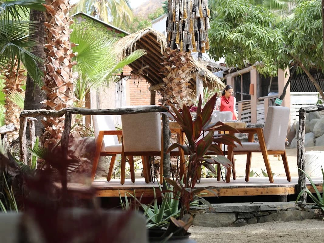 Outdoor dining at DŪM with thatched roof, decorative chandelier in Todos Santos