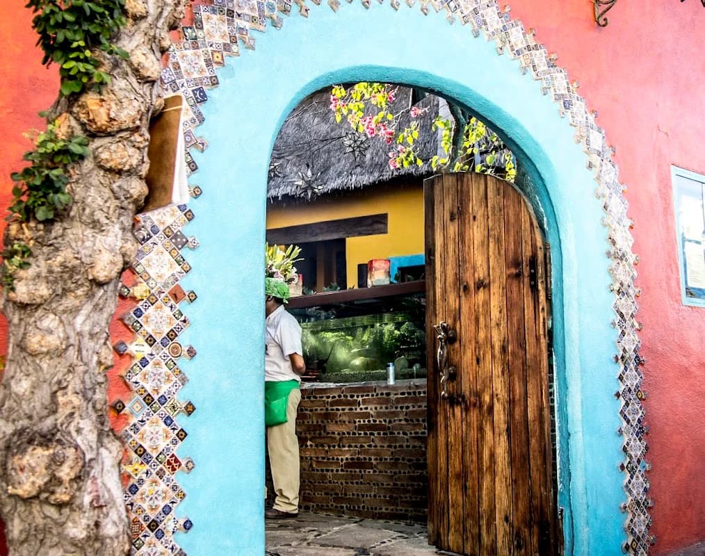 Arched doorway at Edith's Restaurante with person, colorful building exterior in Cabo San Lucas