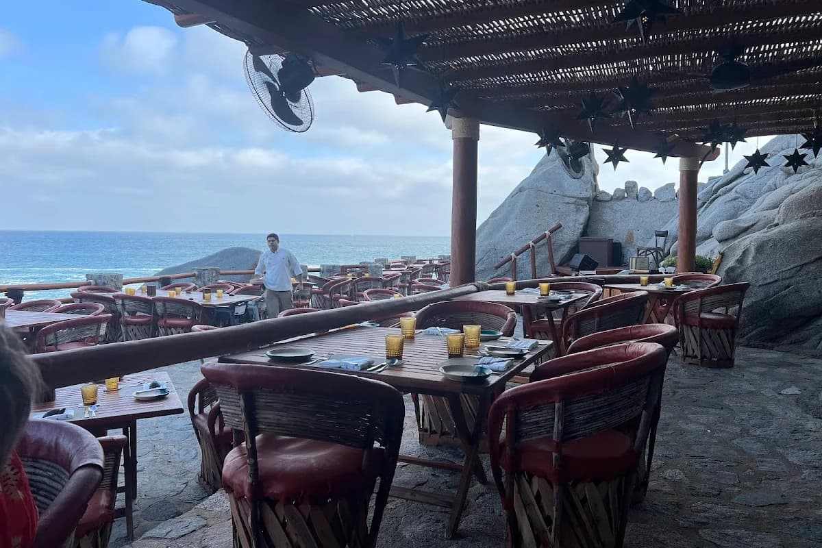 Oceanfront dining at Savor the Savings: Your 2026 Guide to the Best Happy Hour Deals in Cabo San Lucas with thatched roof