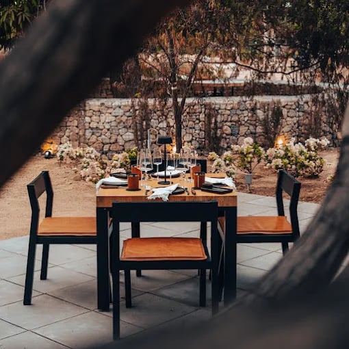 Outdoor dining table at Best Restaurants Along the Cabo Corridor set for dinner, stone wall