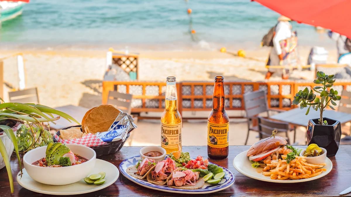 Tacos and beer at Milky Beach Cabo on beach, with ocean beyond in Cabo San Lucas