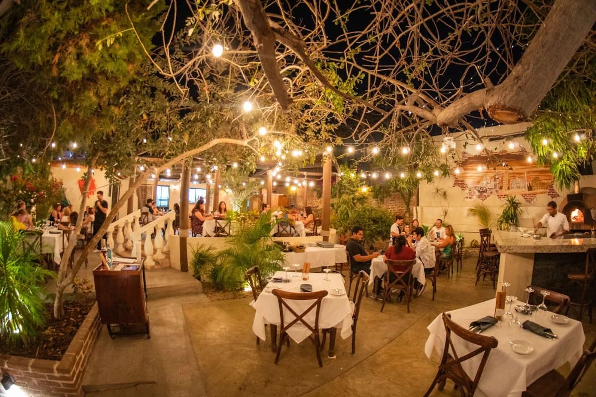 Outdoor restaurant at Pietro's Ristorante at night, under string lights in San José del Cabo