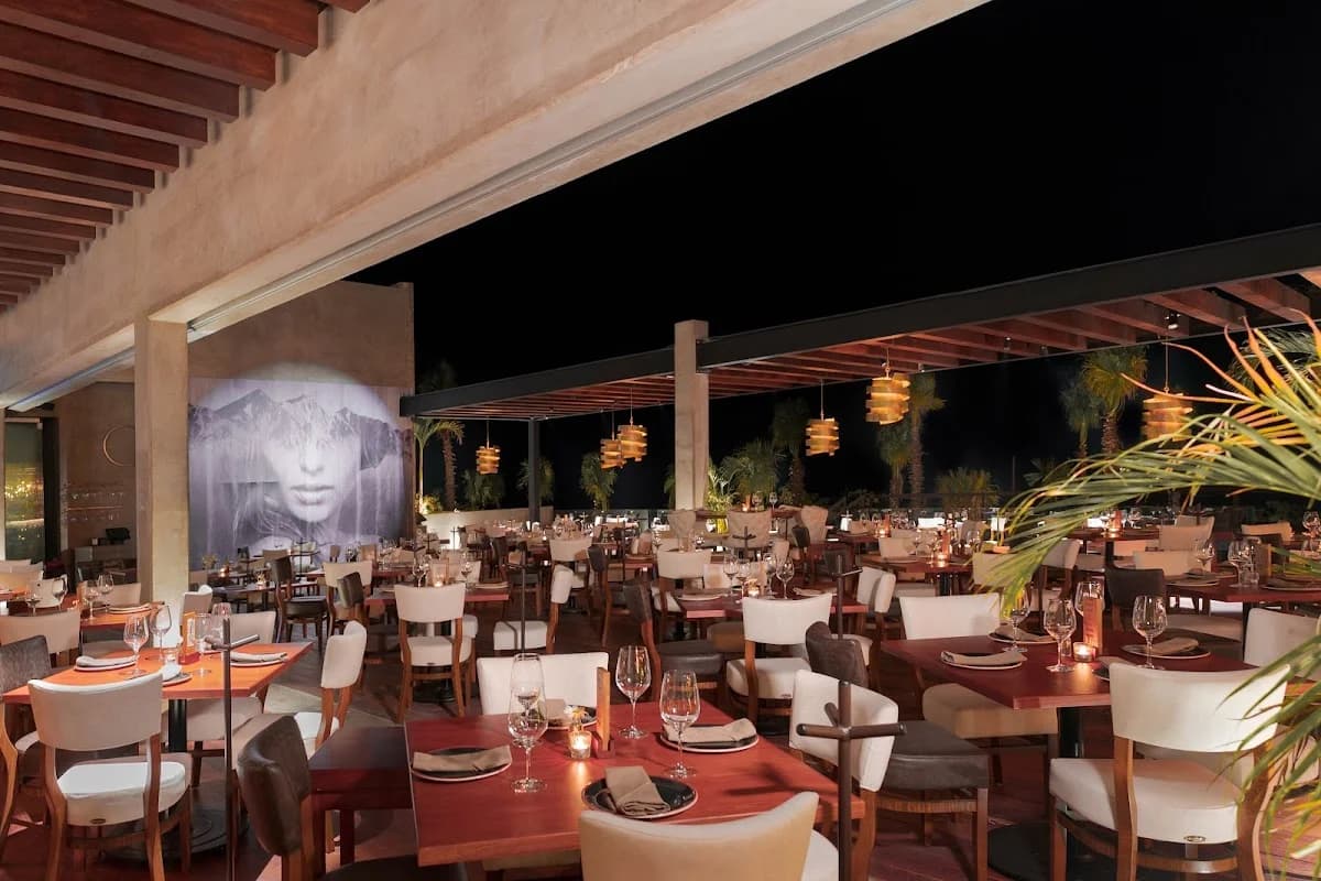 Outdoor dining at RosaNegra Latin American Cuisine at night, empty tables in Cabo San Lucas