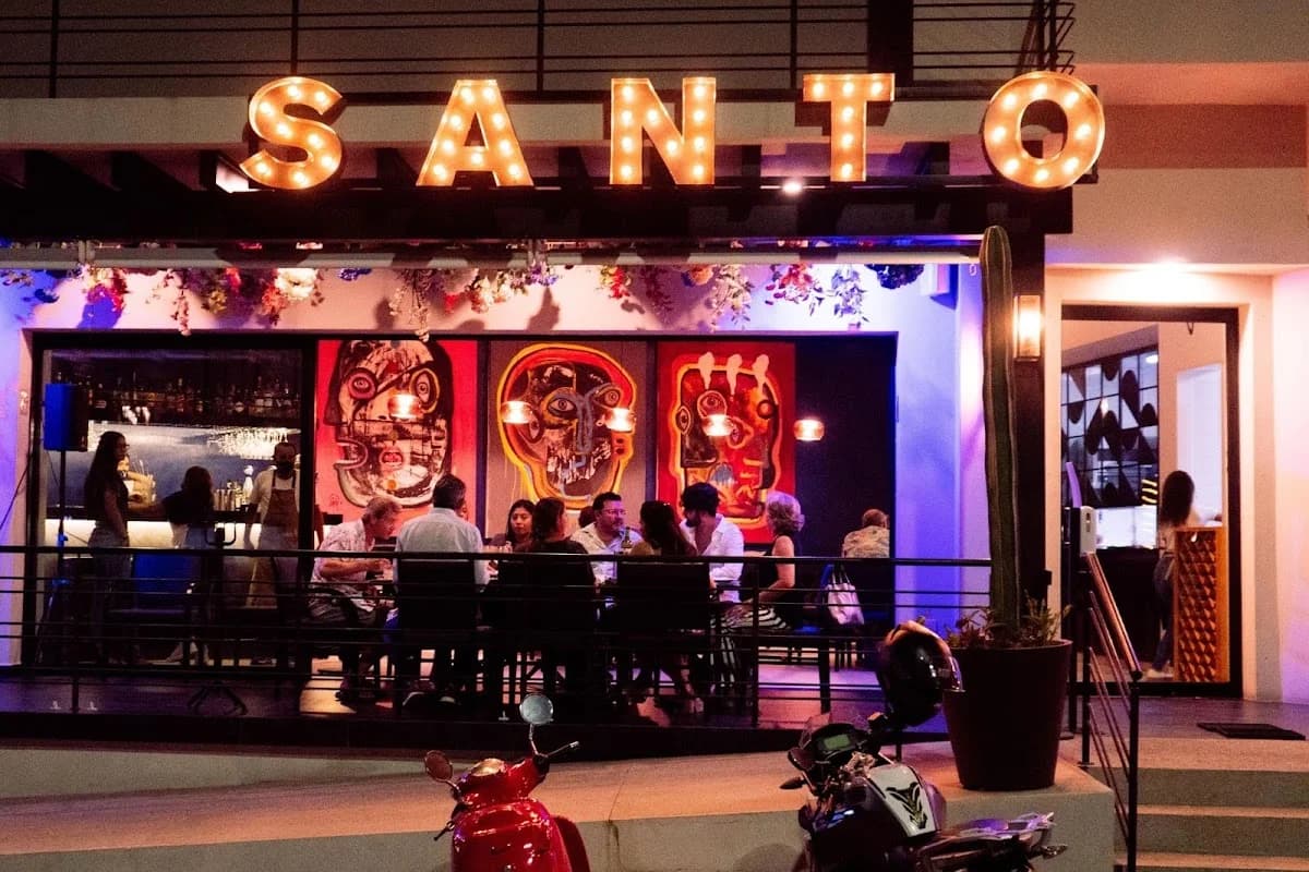 Restaurant exterior at Santo Pulpo illuminated sign, people dining in San José del Cabo