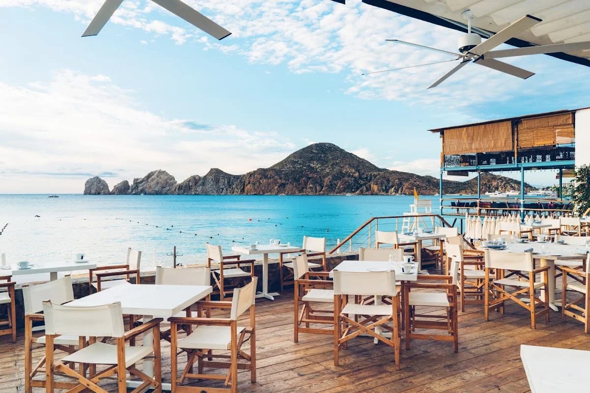 Outdoor dining at SUR Beach Club with ocean and mountain view in Cabo San Lucas