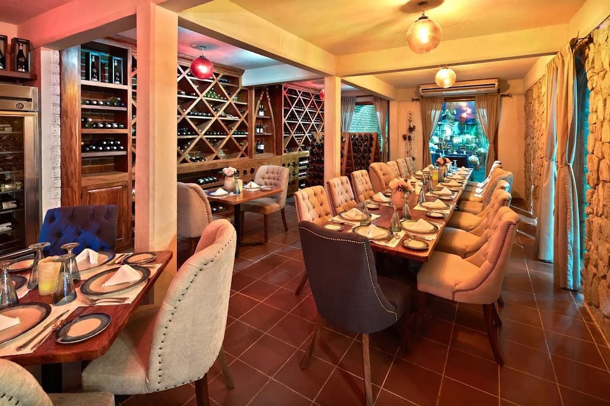 Wine cellar dining at Tres Sirenas with multiple wine racks in Cabo San Lucas