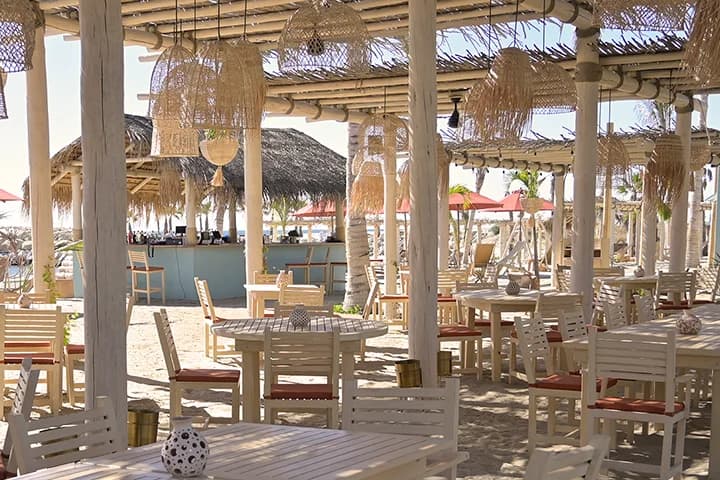 Beach restaurant at Experience the Ultimate El Squid Roe Cabo San Lucas Party in 2026 with straw lamps, on sand