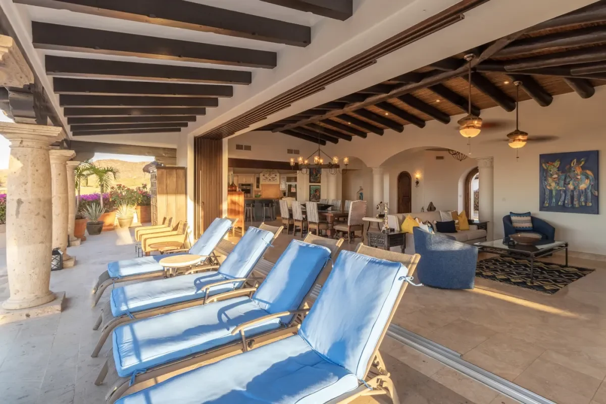Outdoor lounge chairs at Casa Corona with dining room beyond in Cabo Del Sol