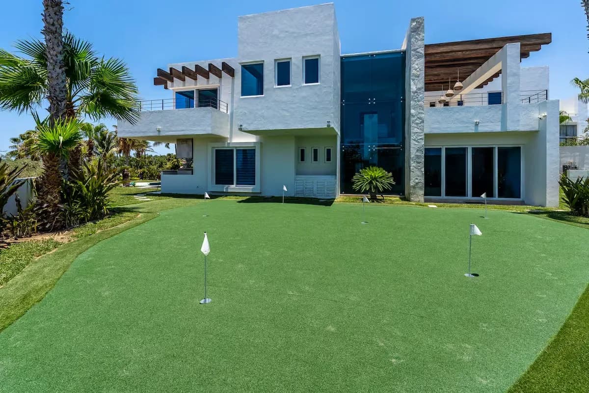 Putting green at Yacht Tours to El Arco Cabo: Best Companies & Times with flags, house in background