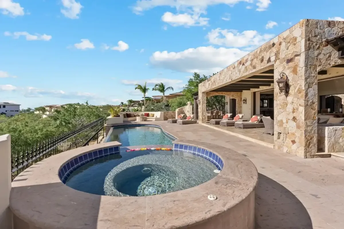 Swimming pool at Casa Kay with spa, under blue sky in Puerto Los Cabos