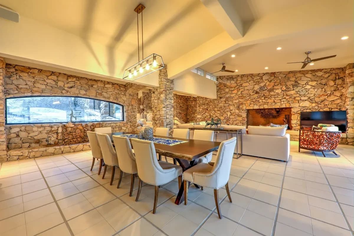 Dining room 1 at Can You Swim At Medano Beach stone walls, long table, chandelier