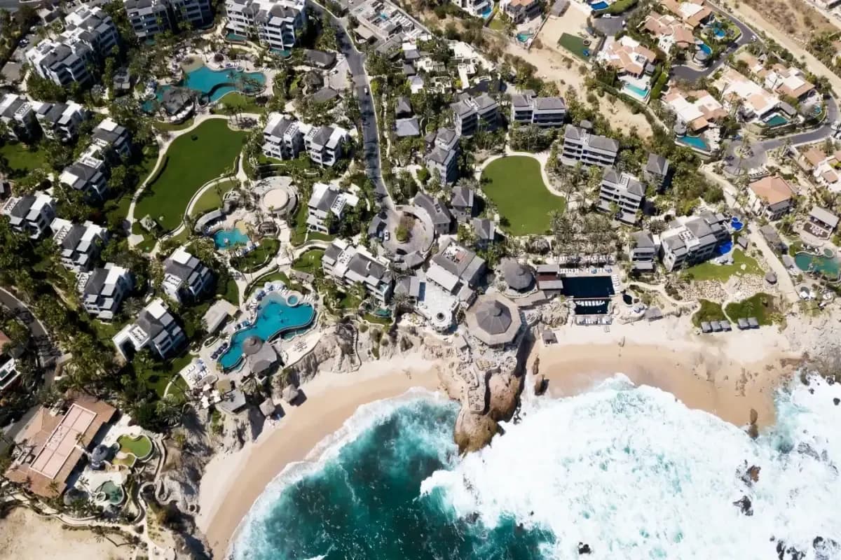 Beach aerial 2 at The Unfiltered Truth: My Guide to the Best Beaches Cabo Has to Offer with resort buildings, ocean