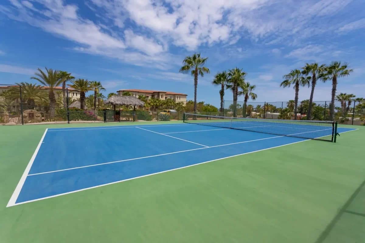 Tennis court at Cabo Wedding Floral Arrangements: Your 2026 Guide to Tropical Blooms outdoors, building and palm trees beyond