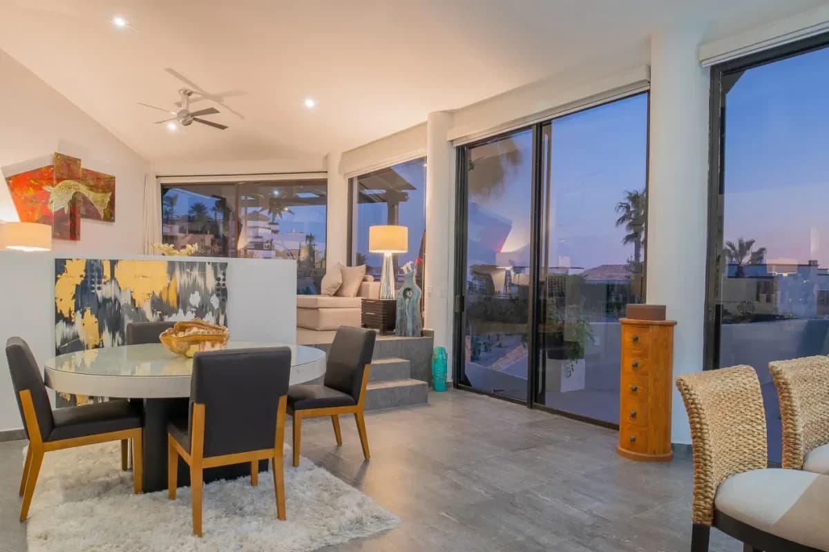 Living dining area at Cabo Villa Amenities: What to Expect from a Luxury Rental in 2026 at dusk, with large windows