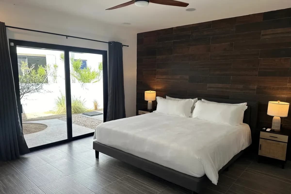 Bedroom 2 at ¡Hoteles en Cabo que no creerás que existen! with wood accent wall, patio door