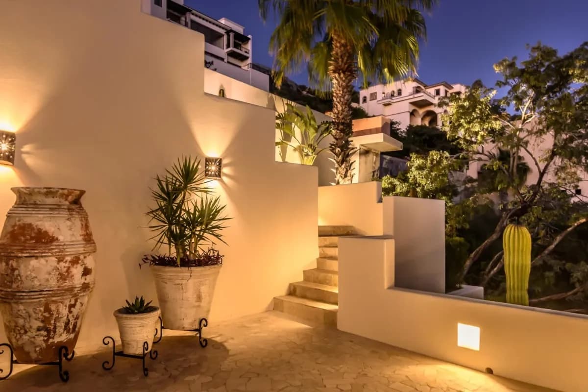 Outdoor staircase at Cabo vs. Hawaii: The Ultimate 2026 Destination Wedding Compare illuminated, at night, with plants