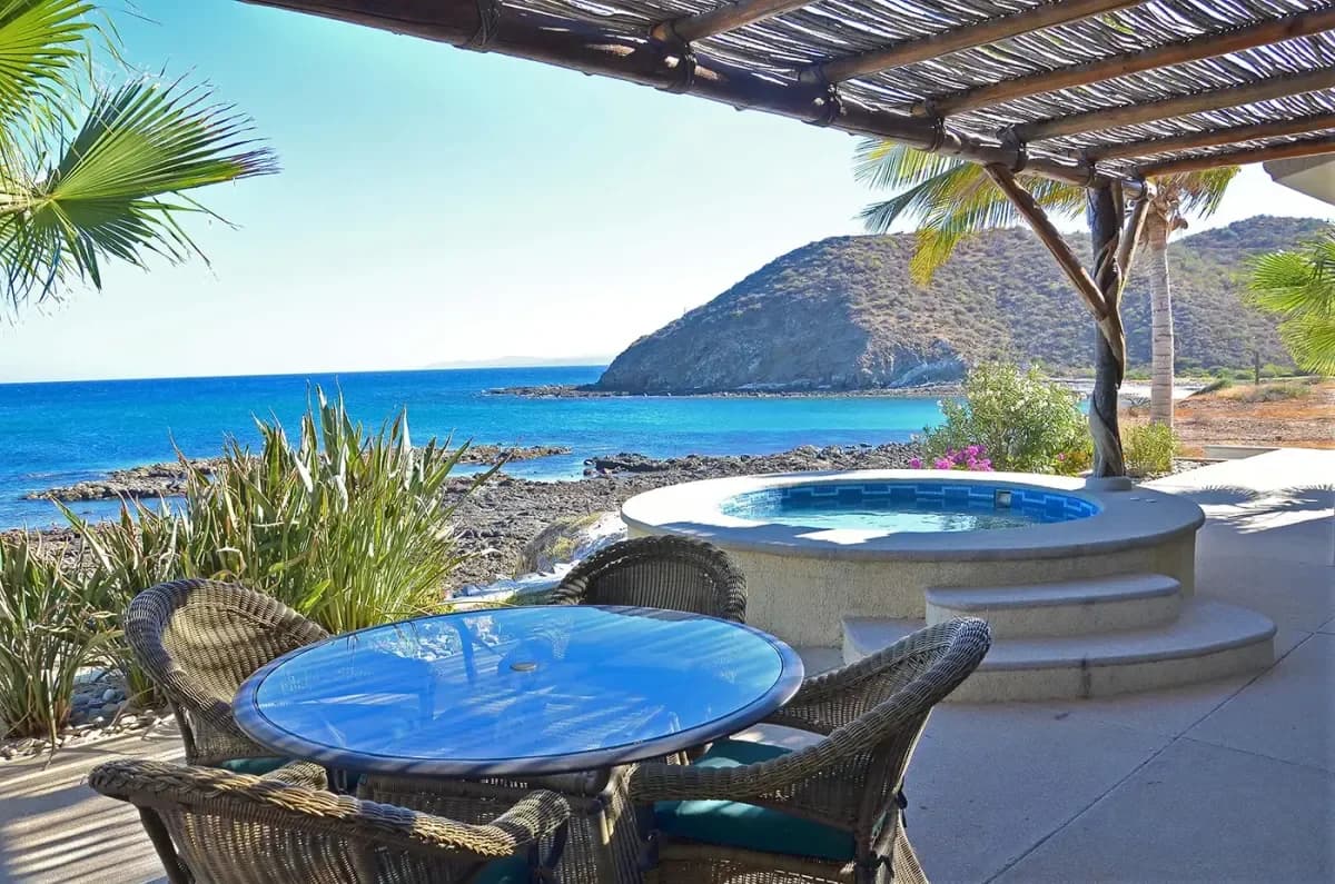 Outdoor dining area at Medano Beach: Cabo's Most Popular Playground, Unfiltered and Unforgettable with ocean and hot tub