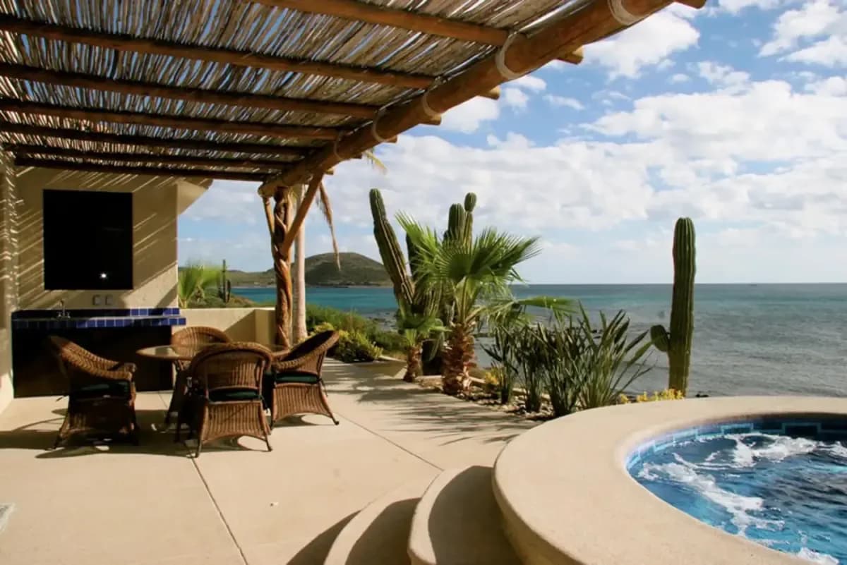 Outdoor patio at Pedregal Pacific vs Palmilla: Which Cabo Villa Area Is Right? with desert plants and ocean
