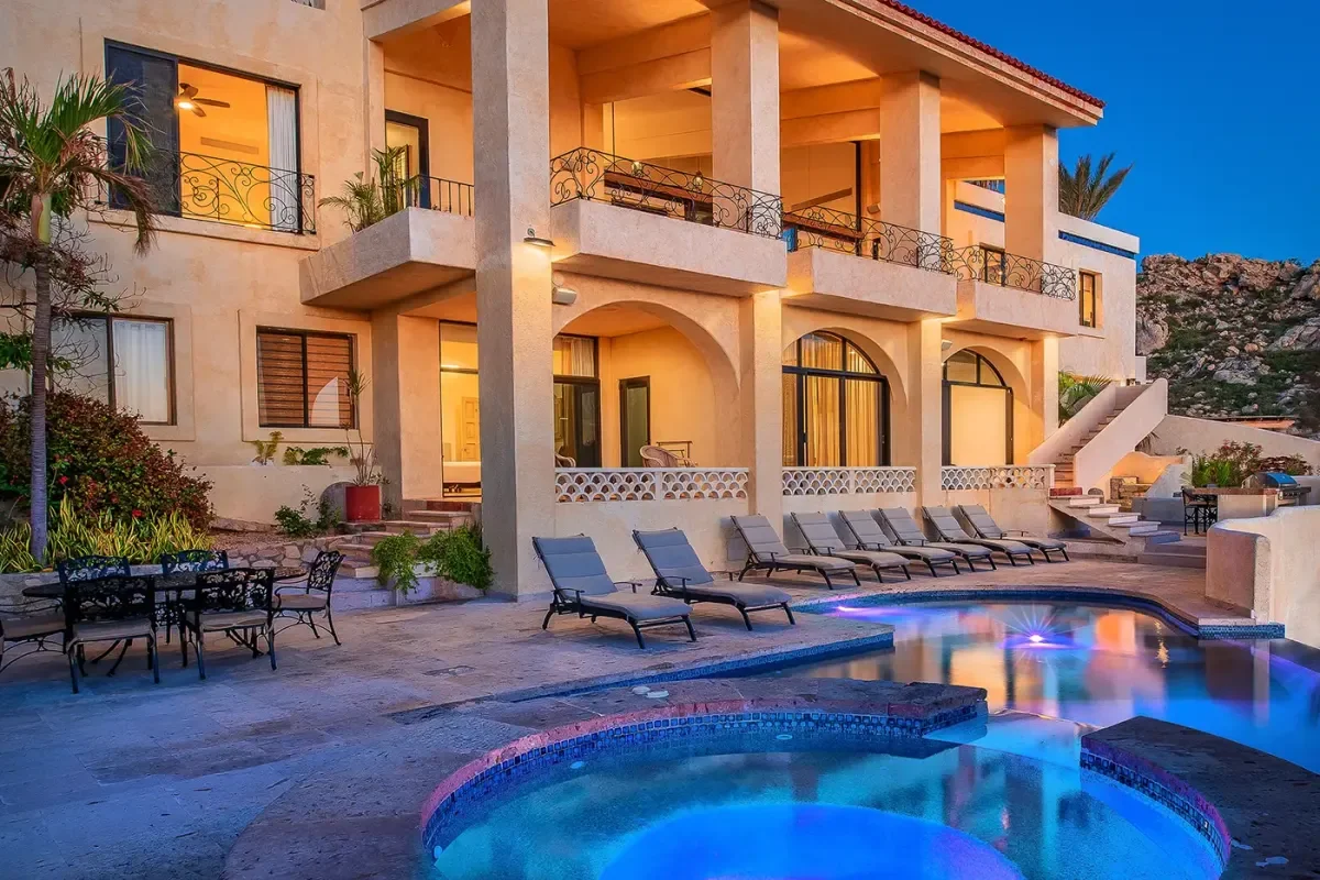 Sunrise Villa, with lit pool, at dusk, in Pedregal Pacific