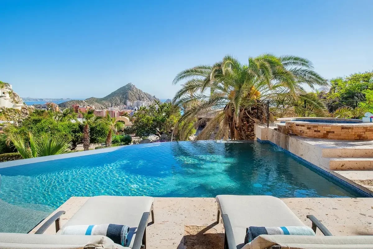 Infinity pool at Sunrise Villa with ocean view, under blue sky in Pedregal Pacific