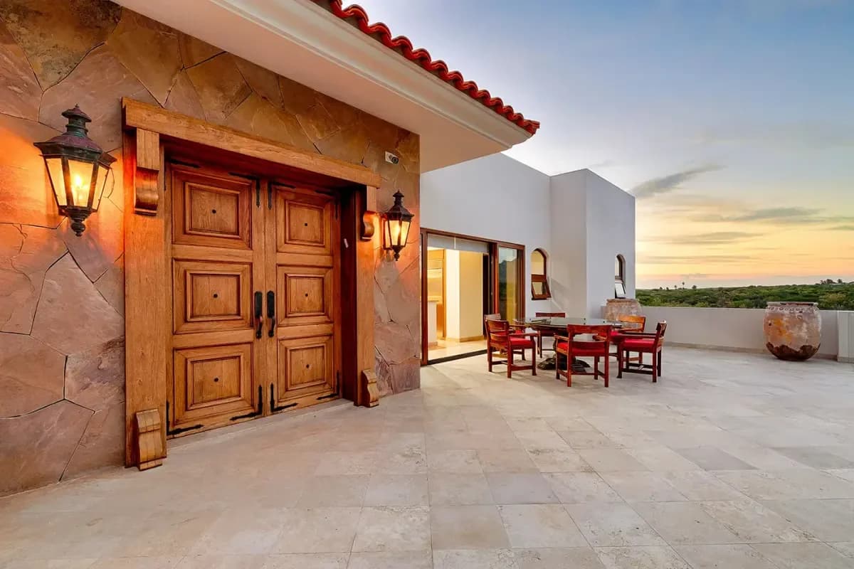 Exterior patio at Discover Your Dream: Cabo San Lucas Luxury Penthouses for Sale in 2026 with wooden door and lantern