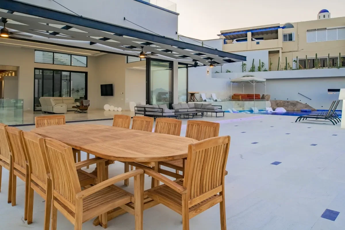 Outdoor dining area at Villa Chavez wooden table, lounge seating beyond in Pedregal Bay