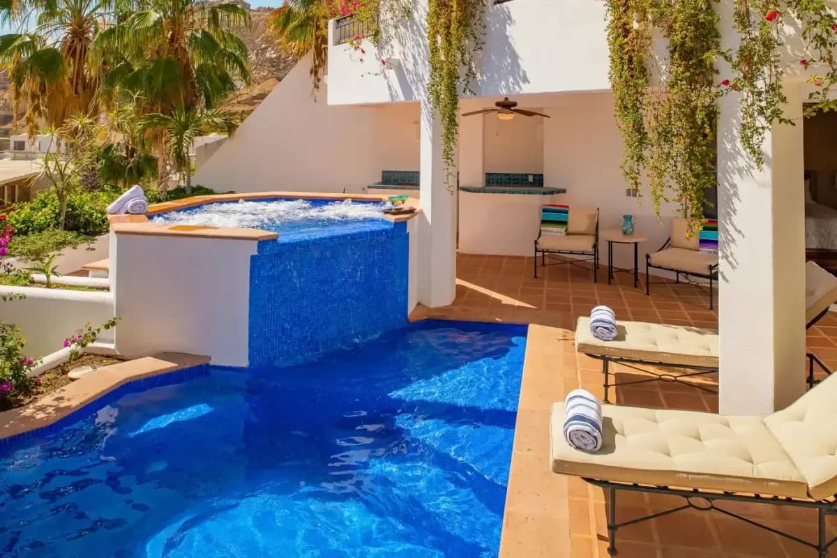 Pool with waterfall at Dolphin Encounter Cabo Cost outdoor bar area visible