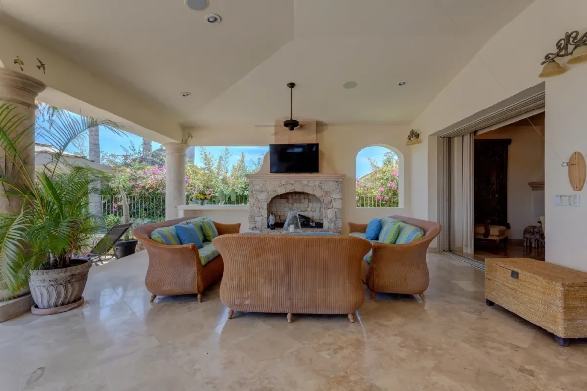 Outdoor living area at Villa Esquina with stone fireplace, television in Cabo Del Sol