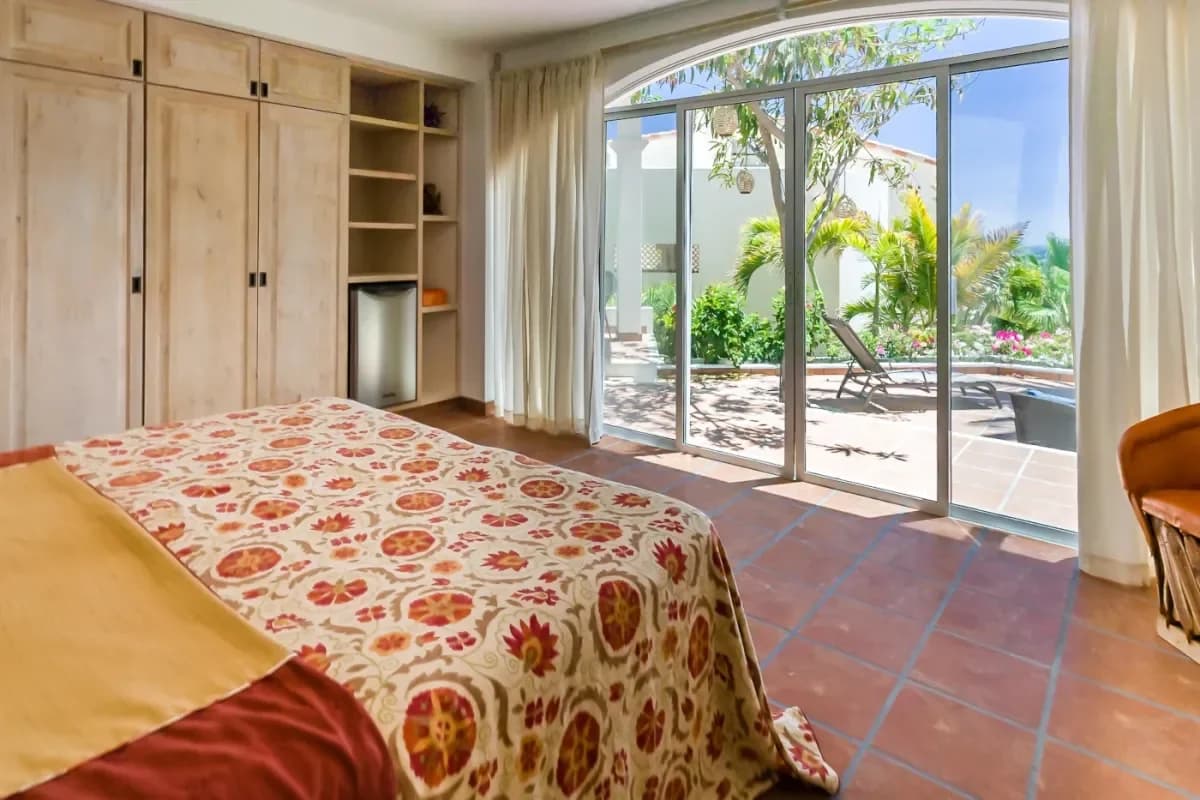 Bedroom 1 at Cabo In February patterned bedspread, patio access