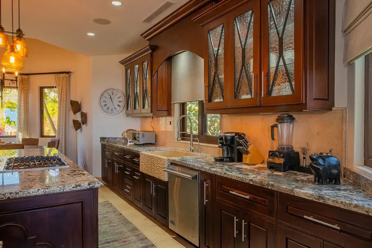 Kitchen sink area at Experience Serenity: Modern Minimalist Villas in Cabo San Lucas for 2026 with dark wood cabinets